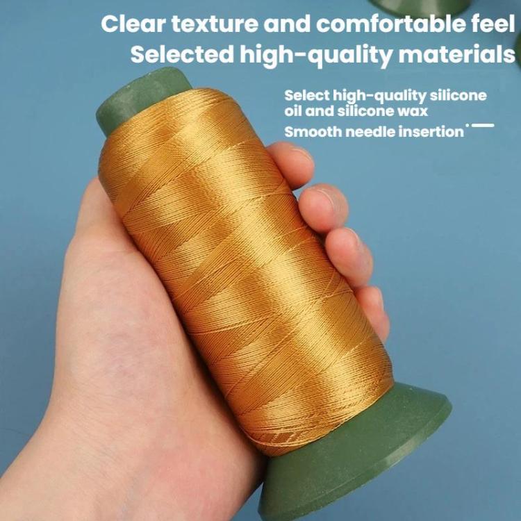 Nylon sewing thread spool, gold/yellow thread held in hand on green base.