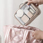 Pink quilted waterproof makeup bag held open with clear compartments and stored cosmetics