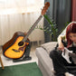 Vertical guitar stand holding an acoustic guitar next to a seated person