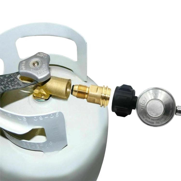 Brass propane adapter mounted on a gas cylinder regulator connection with black knobs
