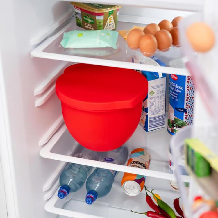 Red silicone mixing bowl lid storing food in refrigerator