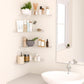 Corner wall-mounted acrylic shelves displaying bathroom toiletries and containers