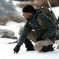 Fleece-lined waterproof pants worn by hiker kneeling outdoors in cold weather