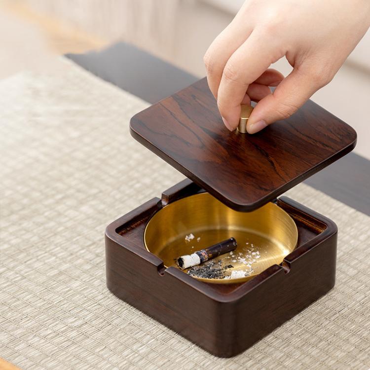 Wood magnetic ashtray with open square base, brass bowl, and hand lifting lid