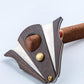 Cigar scissors cutting a cigar with dark wood handles and stainless blade