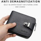 Black compact wallet held in hand, zip closure and metal clasp strap detail