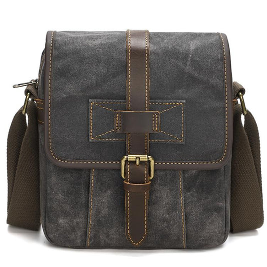 Deep gray waxed canvas crossbody bag with leather cross strap and front buckle