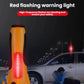 Orange emergency warning light with glowing red lens on tall handle