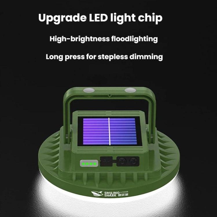 Solar-powered camping light with green housing and glowing solar panel, dimming buttons