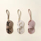 Three hanging PU leather eyeglasses cases with wrist straps in brown, white, and pink