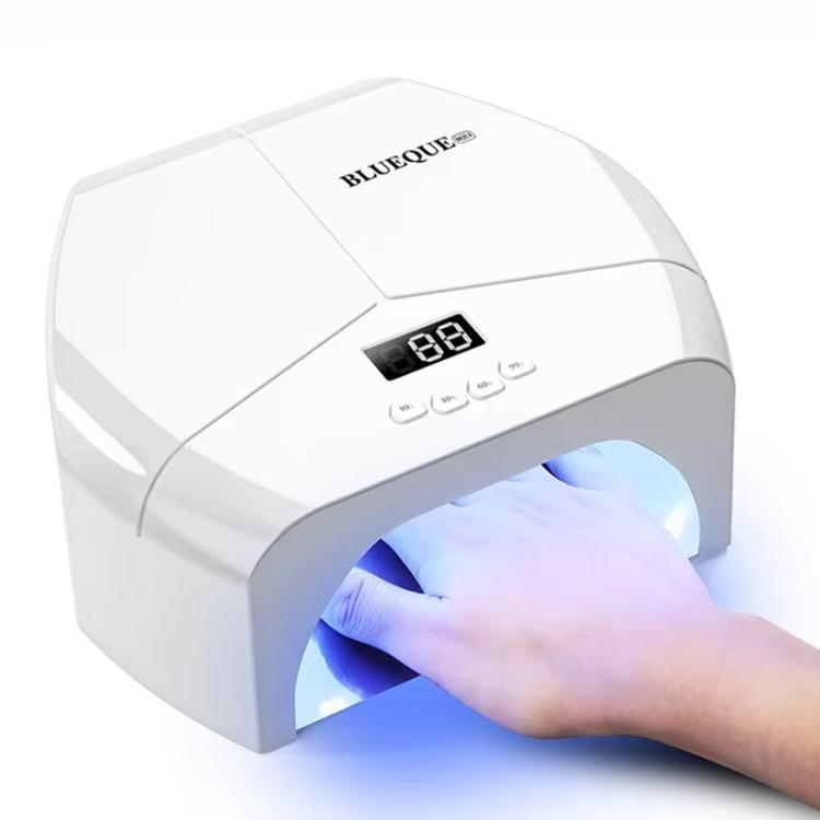 White nail gel curing lamp showing digital display; hand under illuminated chamber