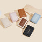 Set of compact zip card wallets in multiple colors, shown stacked.