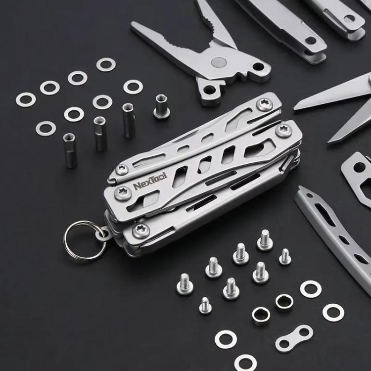 Silver multitool pliers keychain with included small screws and bits, close-up