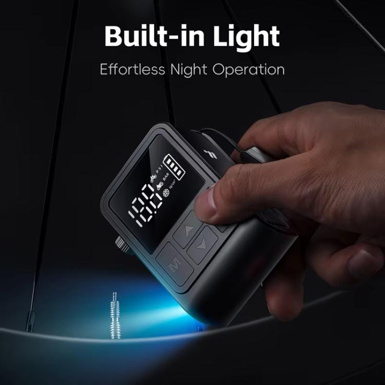 Black digital air pump inflator with built-in light glowing in dark setting while held