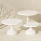 White tiered cake stand set with three round plates on pedestal bases