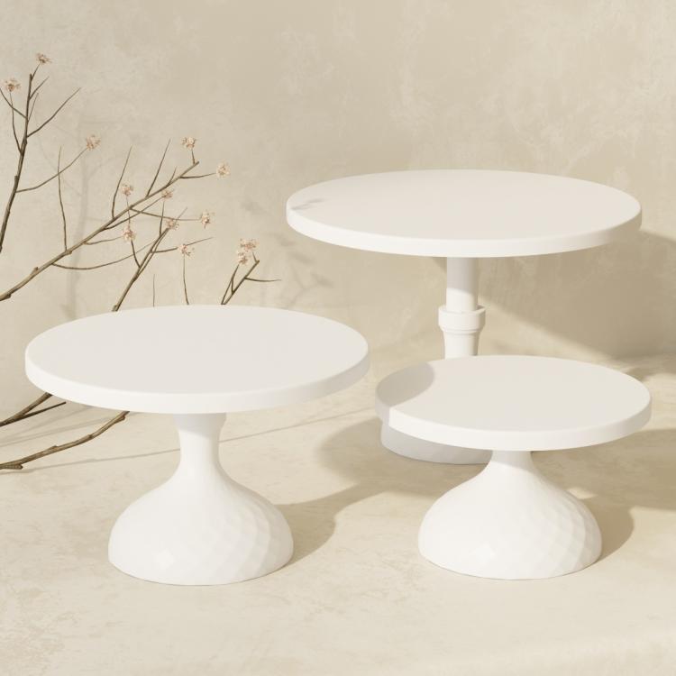 White tiered cake stand set with three round plates on pedestal bases
