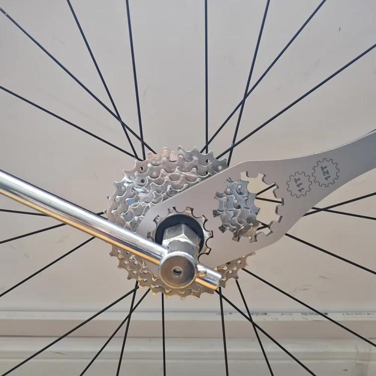 BIKERSAY freewheel removal tool on rear wheel, turning a cassette lockring with 11T/12T head