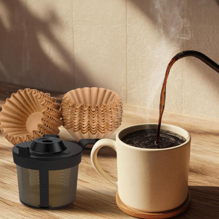 Reusable stainless steel coffee filter with black lid next to a brewed coffee mug