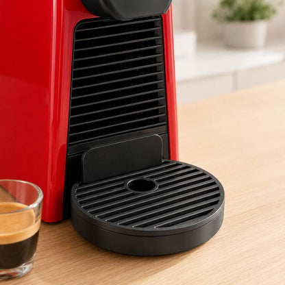 Black circular espresso drip tray with slotted grate and center drain hole