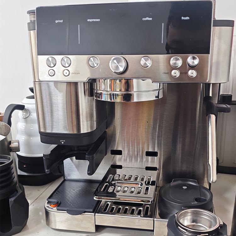Coffee grounds catcher mat installed on a coffee machine drip tray, dark gray