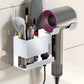 White wall-mount hair dryer holder with divided storage slots for styling tools.