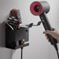 Hand installs black wall-mount hair dryer holder with divided tool storage.