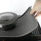 Grey silicone mat with ribbed texture and lifted edge near espresso machine