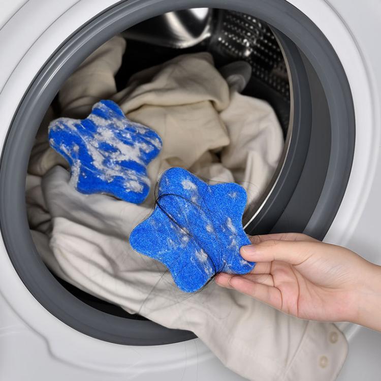 Blue felt star lint remover pads inside washing machine drum with hair