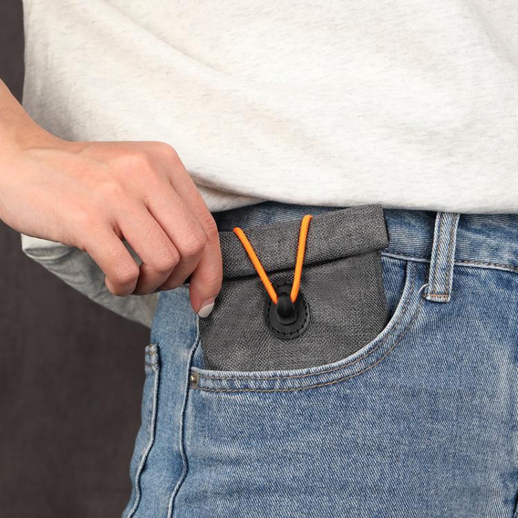 Gray drawstring pouch with snap toggle tucked into a jeans pocket
