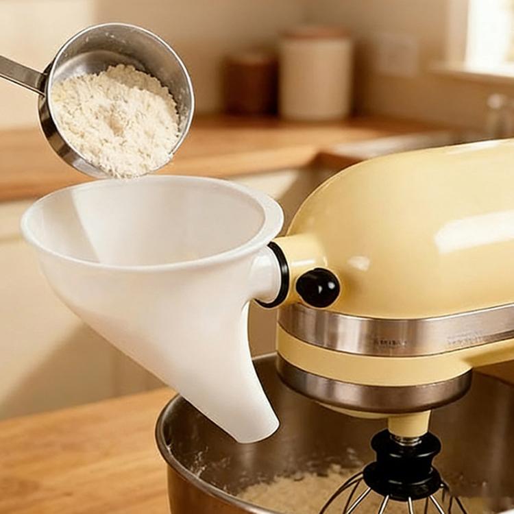 White flour funnel attachment dispensing flour into stand mixer bowl