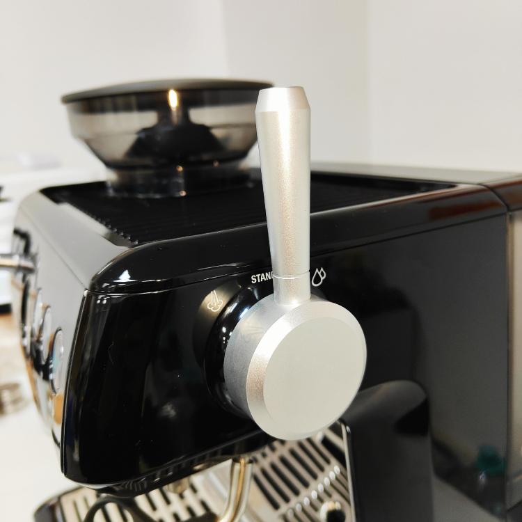 Silver external steam switch lever with round pull knob on espresso machine