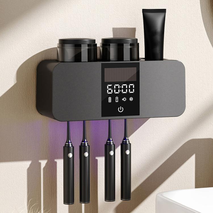 Black wall-mounted toothbrush holder with two cups and four toothbrushes stored vertically