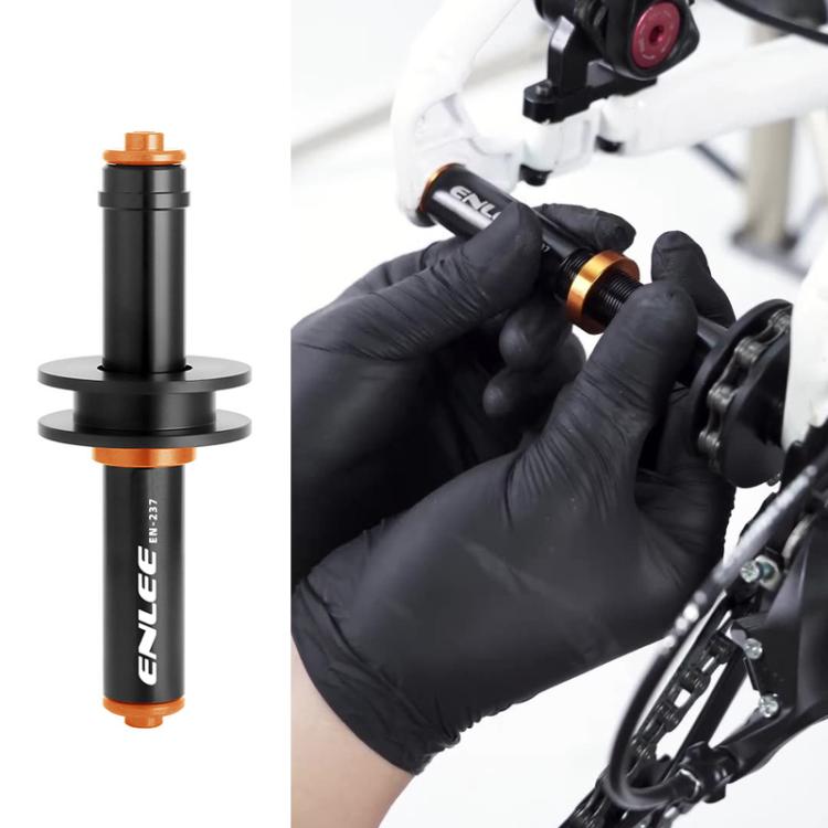 Bike chain keeper holder, black and orange cylinder shown being installed by gloved hands