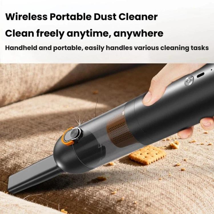 Black handheld cordless vacuum cleaner nozzle cleaning crumbs on a fabric surface