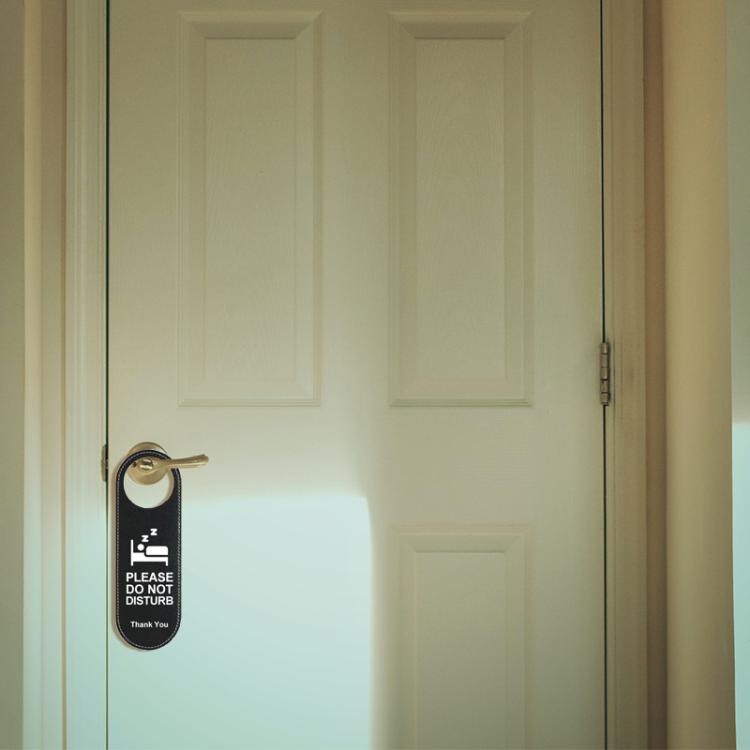 Black leather door hanger sign on a knob, “Please Do Not Disturb” side with Thank You text.