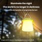 Hanging camping lantern glowing warm yellow light with arched handle