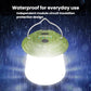 Green hanging camping lantern glowing bright white in wet conditions