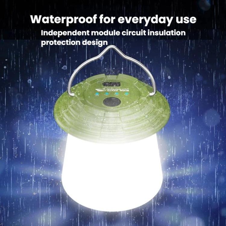 Green hanging camping lantern glowing bright white in wet conditions