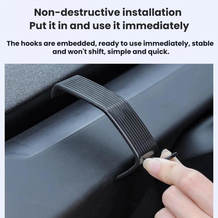 Hand pushing a black ribbed dashboard hook into a console slot
