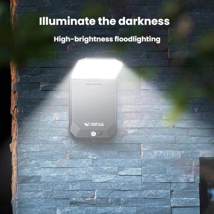 Solar motion sensor garden wall light mounted on a stone wall, glowing white