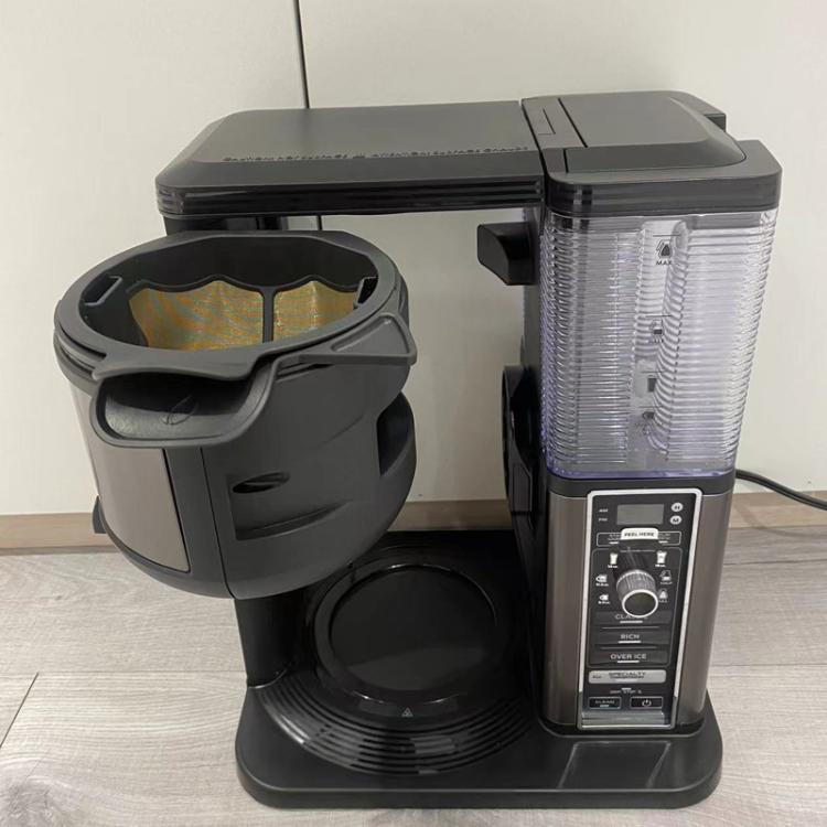 Black mesh filter basket on coffeemaker base, front view