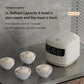 White electric rice cooker with four small serving bowls of cooked rice