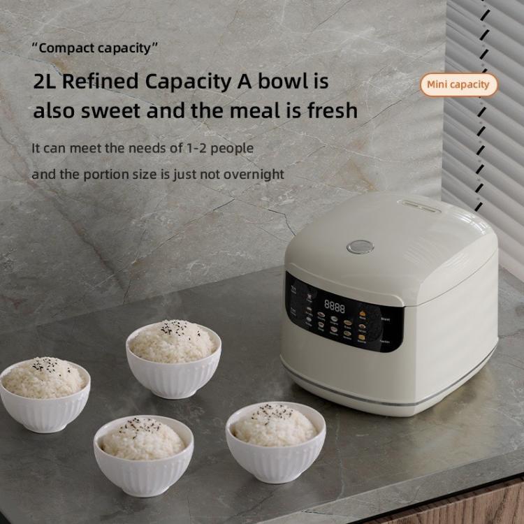White electric rice cooker with four small serving bowls of cooked rice
