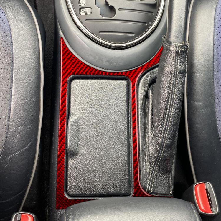 Red carbon-fiber cupholder frame sticker around cupholder recess in car interior