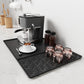 Black silicone draining tray mat with raised loop-pattern ridges for coffee machine