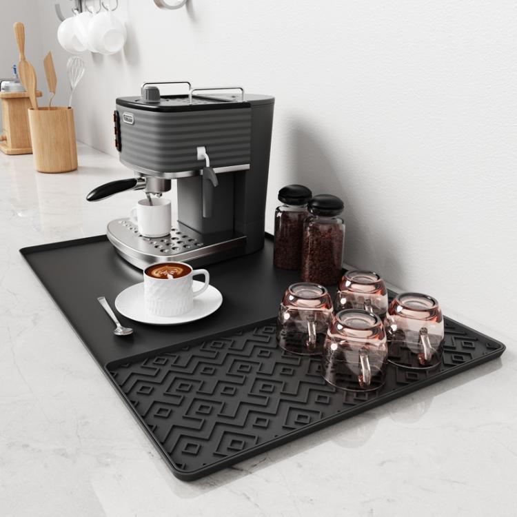 Black silicone draining tray mat with raised loop-pattern ridges for coffee machine