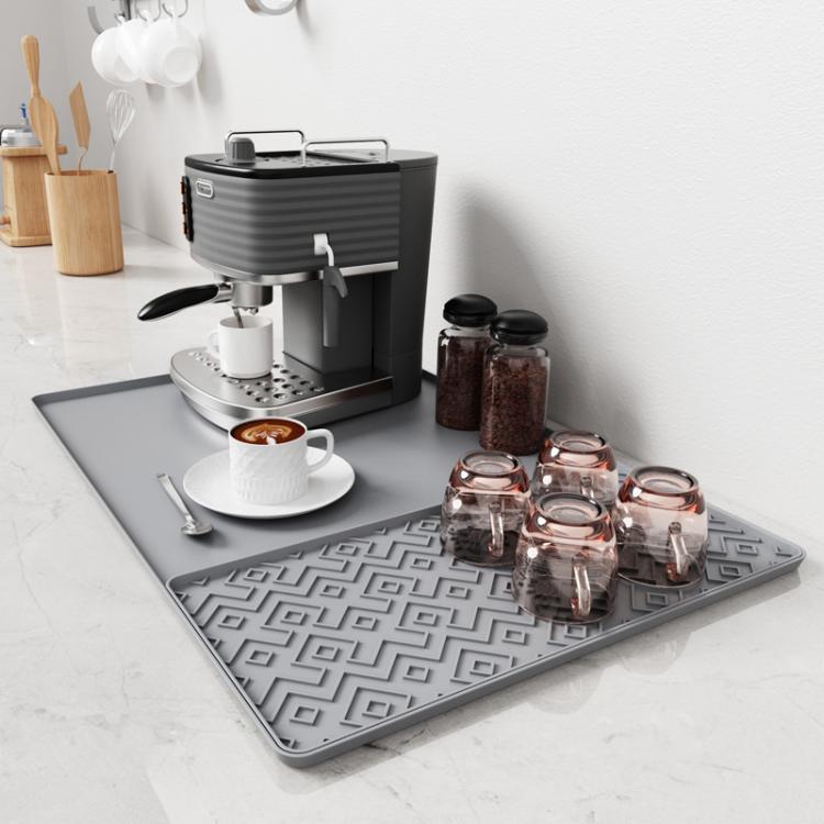Gray silicone draining tray mat with raised loop-pattern ridges for coffee machine