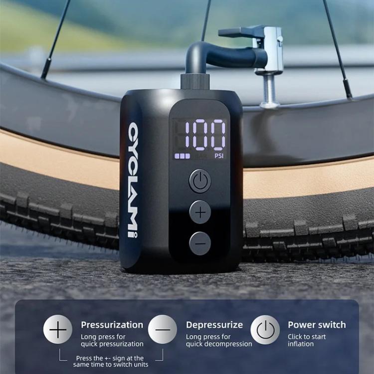 Electric mini air pump standing on road tire with digital pressure display