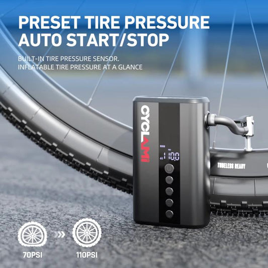 Portable air pump with hose nozzle on the ground beside bicycle tires