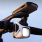 Bicycle remote headlight flashlight mounted on handlebar, showing front lens and logo.